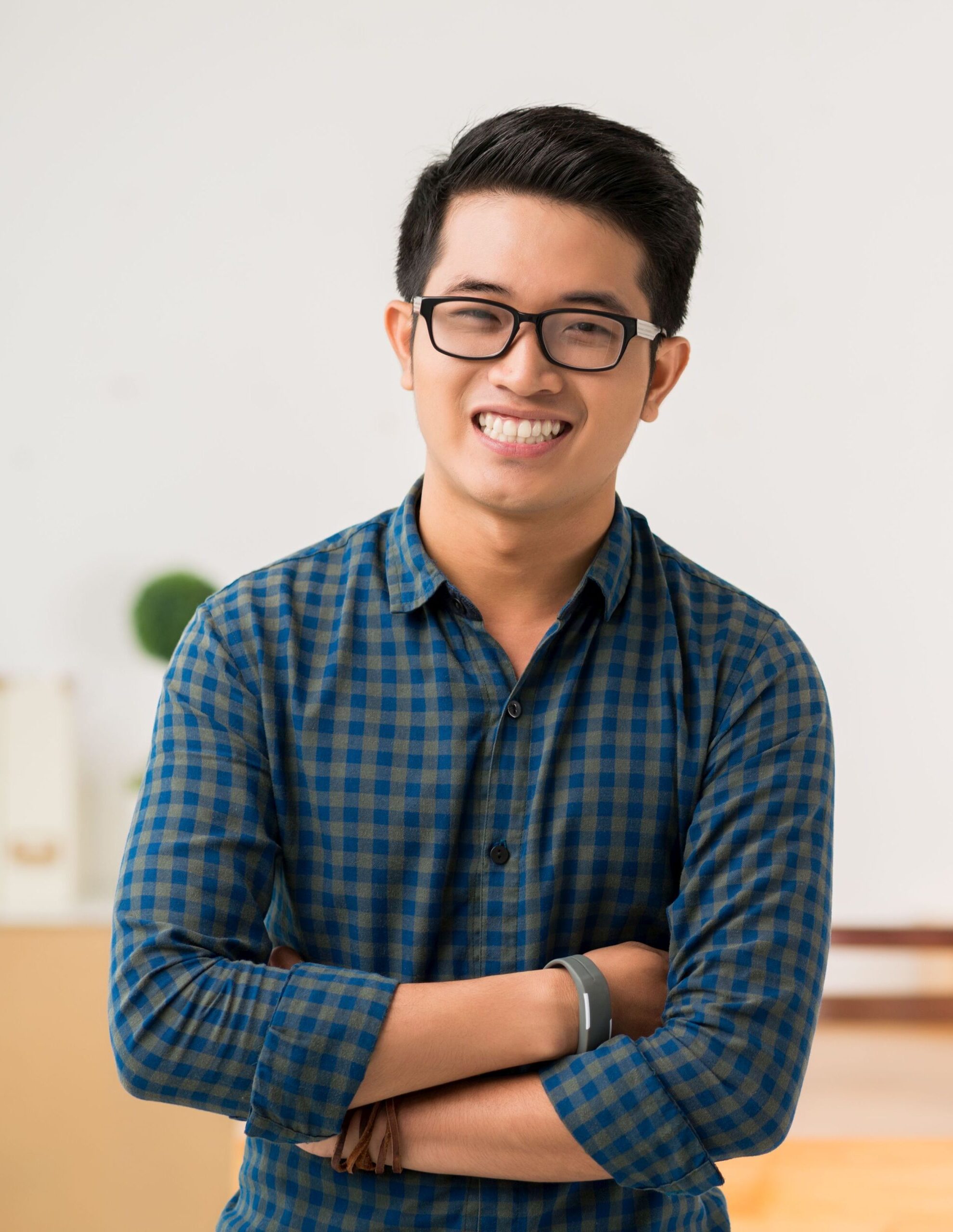 Smiling Vietnamese young man in glasses looking at camera